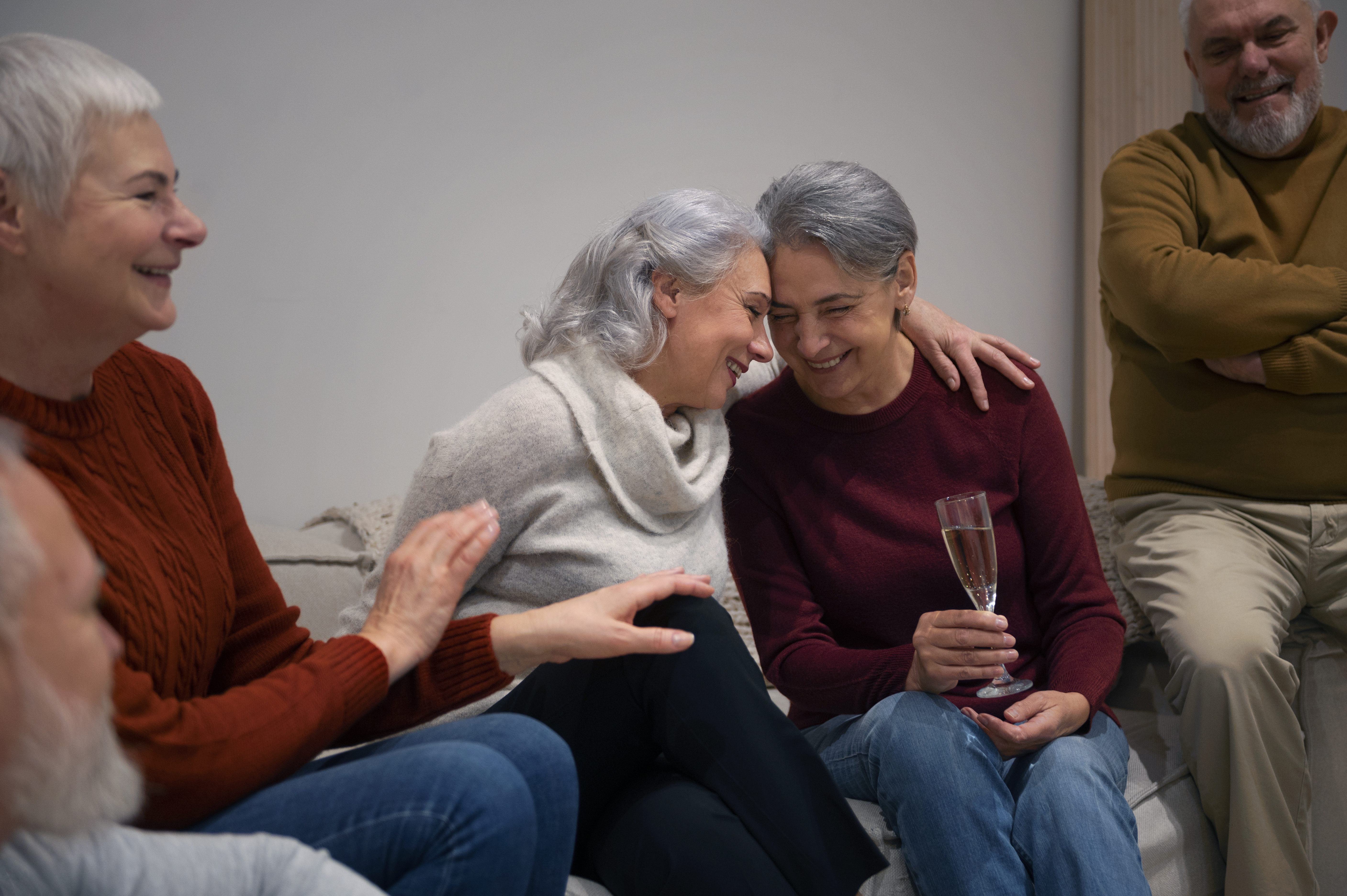 A happy senior woman enjoys a cup of tea in a bright, comfortable living space.